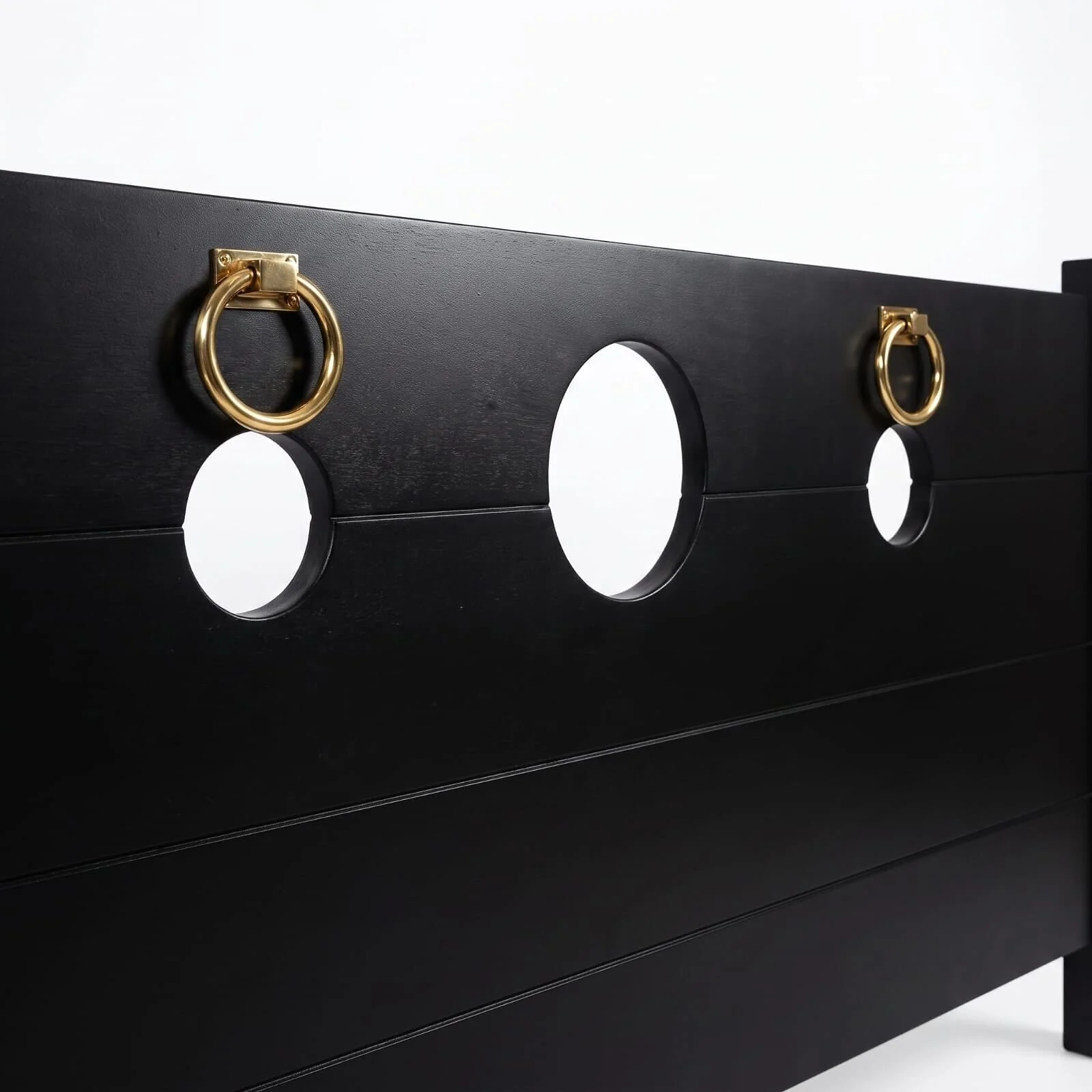 Close-up of the Onyx Black footboard: gold-tone rings beside the round cut-outs