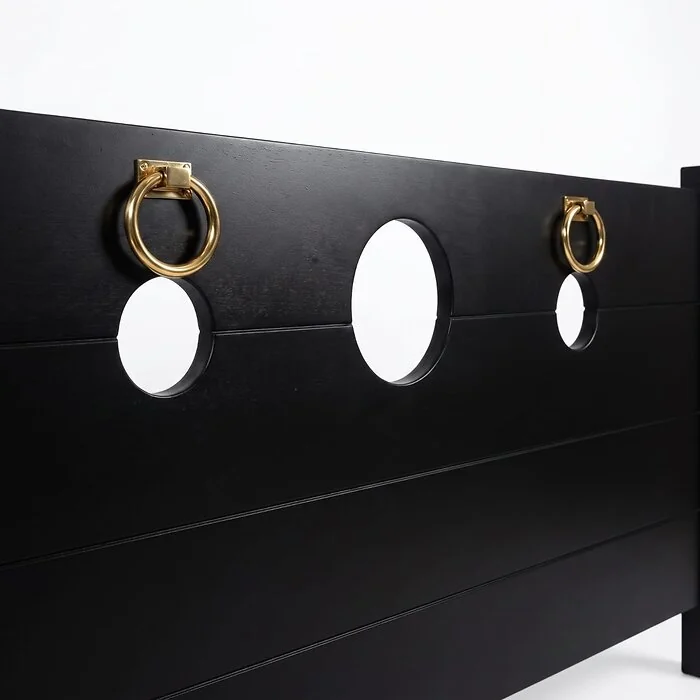 Close-up of the Onyx Black footboard: gold-tone rings beside the round cut-outs
